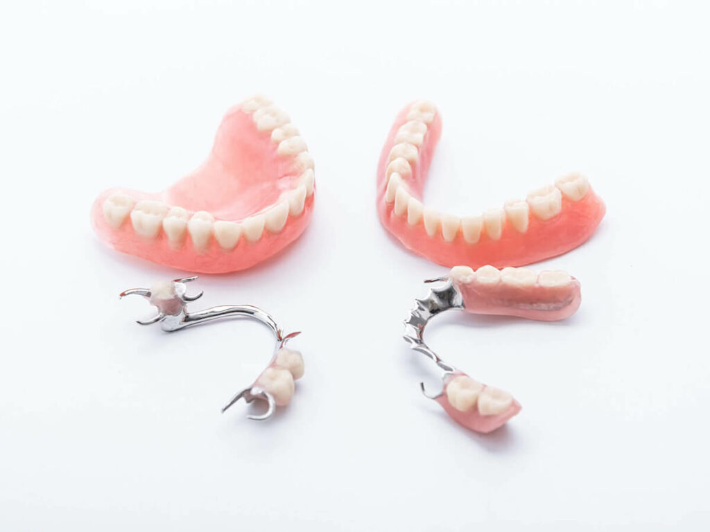 Full and partial dentures on white background